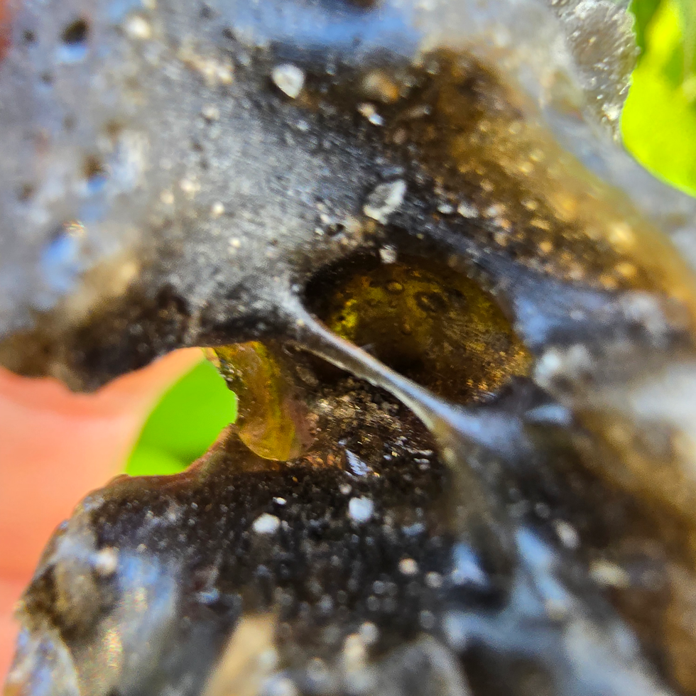 Thumbnail: Close-up of a rough, dark green Moldavite stone