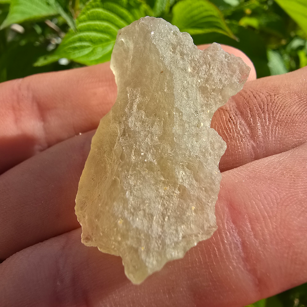 Thumbnail: Libyan Desert Glass, pale yellow and translucent, held in a hand