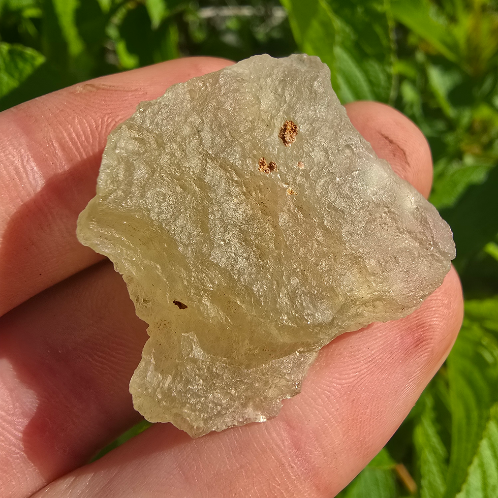 Thumbnail: Hand holding a piece of Libyan Desert Glass