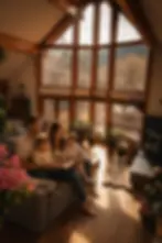 Family reading in a cozy mountain living room with floor-to-ceiling windows showcasing Boulder CO forest views and natural
