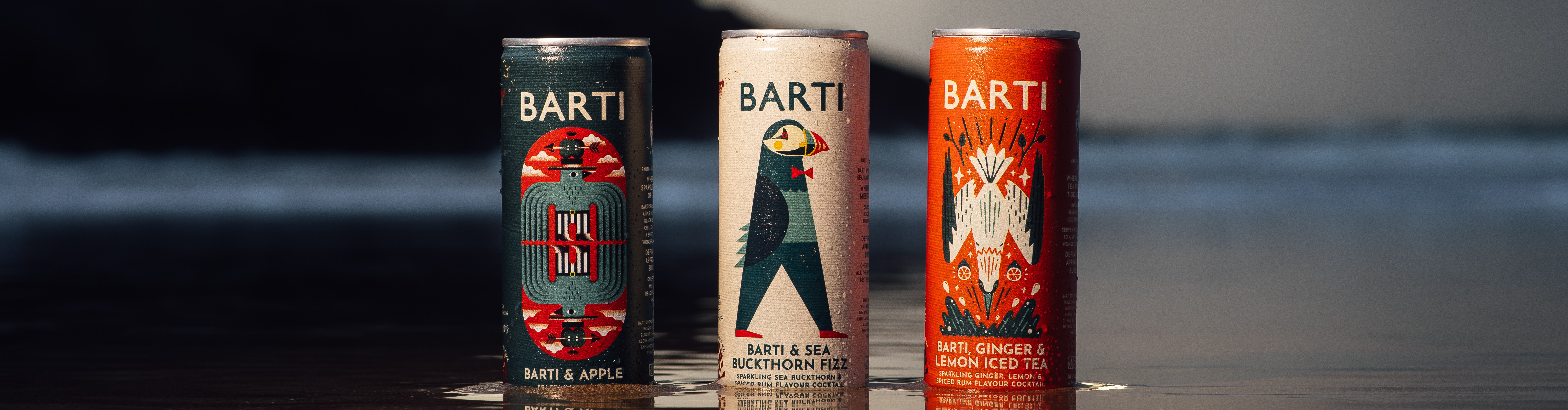 Three BARTI drink cans on reflective water at sunset, with a moody sky and dark island silhouette.