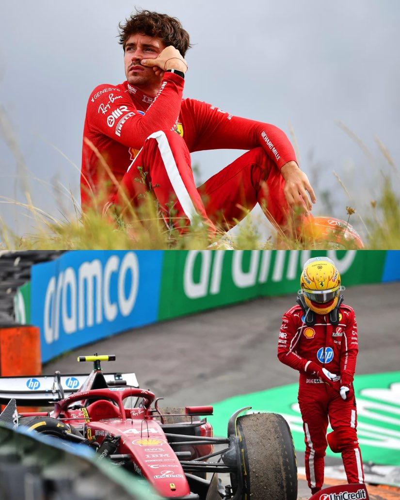 Race car driver in red suit sits pensively in grassy area; damaged red car, helmeted figure nearby, green and blue sponsor wall behind.