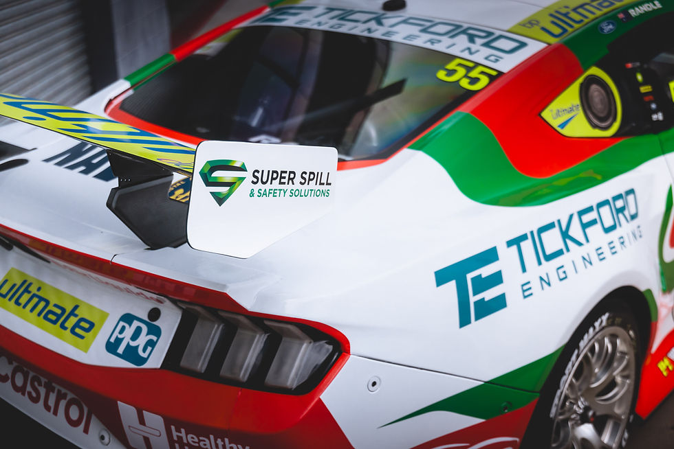 Racing car with colorful decals, including Super Spill & Safety Solutions. Vibrant red, green, and white colors. Number 55 visible.