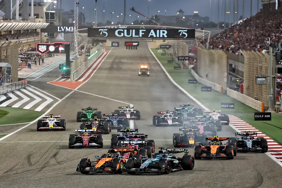 Race cars speed down a track under a "Gulf Air" banner. Crowded stands, motion blur, and diverse car colors create a dynamic scene.