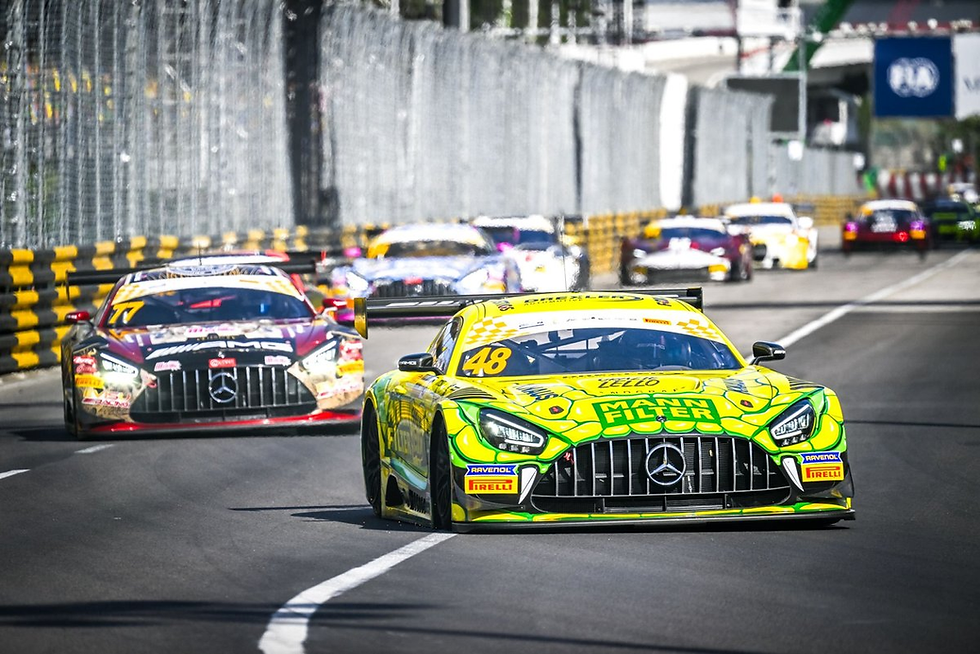 Bright yellow Mercedes race car #48 leads a pack on a city street circuit, with other GT cars behind and sponsor logos visible.
