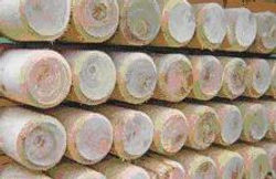 Stack of oak round wooden poles, ideal for outdoor projects.