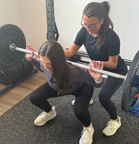Dr. Kari Schlarmann helping with barbell squat