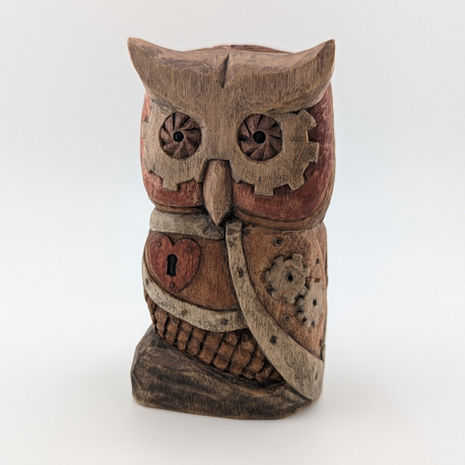 a carved wooden owl with a heart on its chest