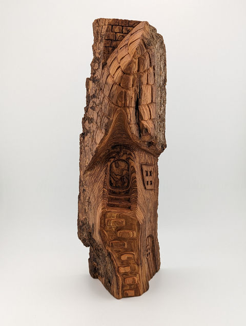 a sculpture of a house carved into a piece of wood