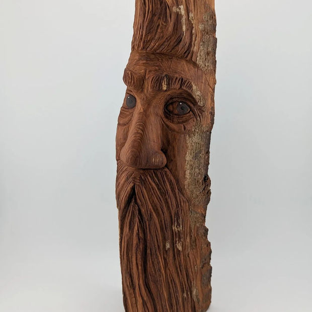 a wood carving of a man with a beard