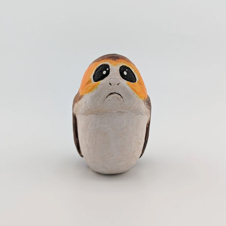 a wood carving of a brown and white bird with a sad look on its face