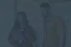 Two colleagues wearing ID badges and talking about work