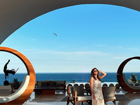 A girl standing in the lobby of Marquis Los Cabos with the Pacific Ocean in the background.
