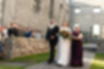 Alanna (the bride) walks down the asile at St. Raphael's Ruins on a sunny day in Fall.