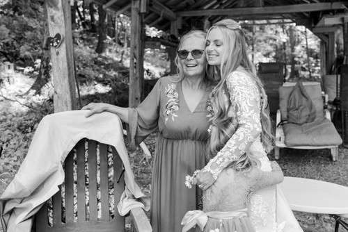 The Bridal Party stands on the dock by the water.