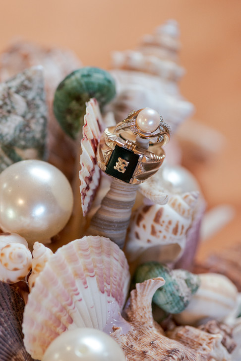 The couples wedding rings on the seashell bouquet