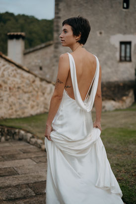 Braut auf einer Hochzeit in Mallorca in einem eleganten Hochzeitskleid mit tief ausgeschnittenem Rücken, fotografiert von einem Hochzeitsfotografen für stilvolle Destination Weddings.
