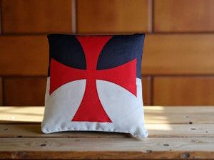 Coussin décoratif avec une croix rouge, fond blanc et bleu. PLACE DU TEMPLE.