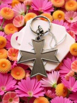 Un porte-clés croix de chevalier, sur une base blanche, Recueil de prières et fleurs.