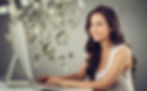 a woman smiling as she works at computer