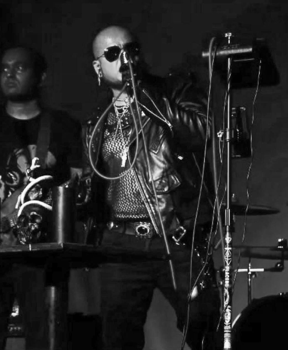 Black and Grey portrait of  Vinn Morgue of Stereoccult singing into microphone on stage.