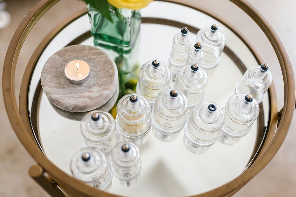 Massage cupping cups on on a galss table nex to a candle