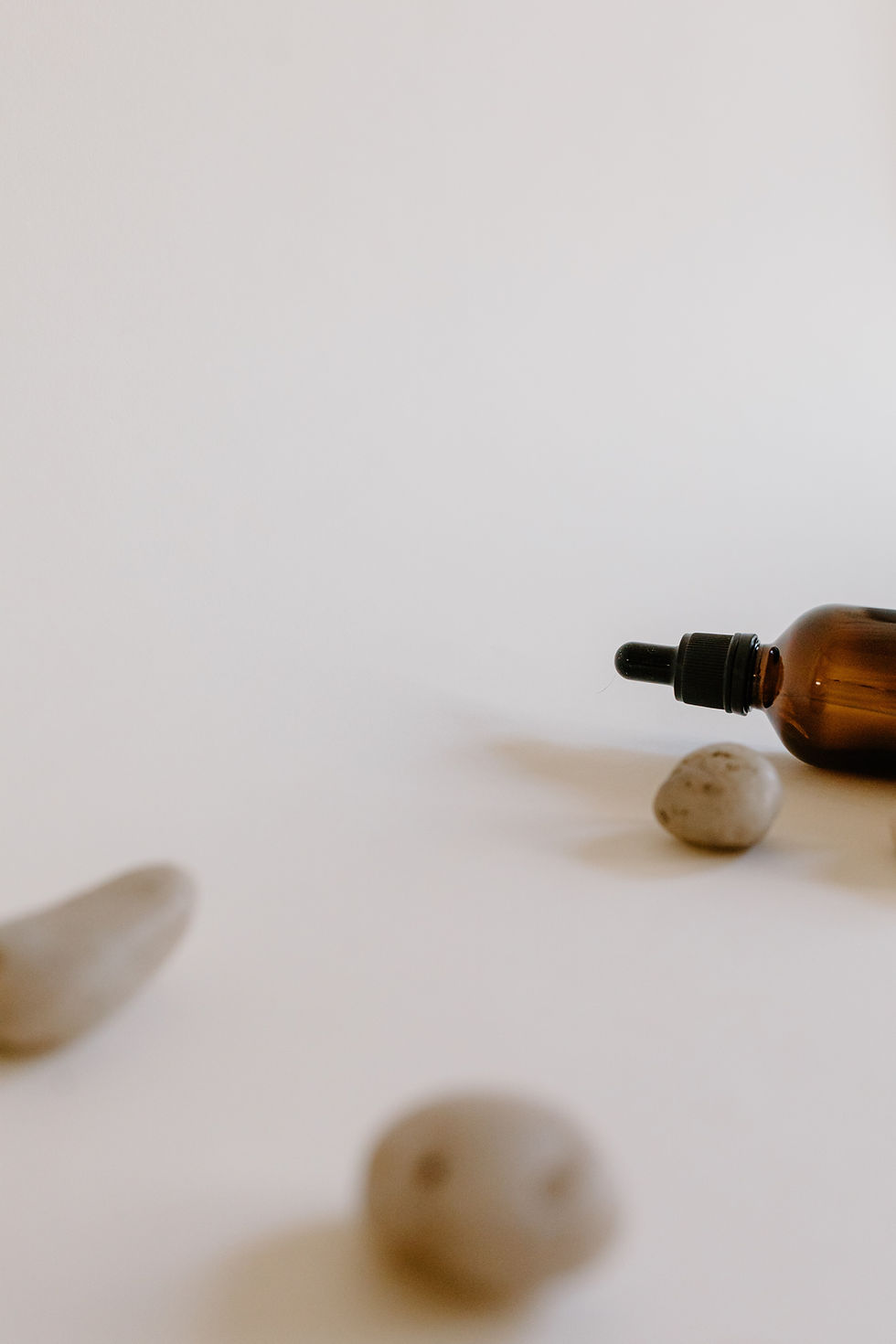 Massage bottle on its side with three rocks