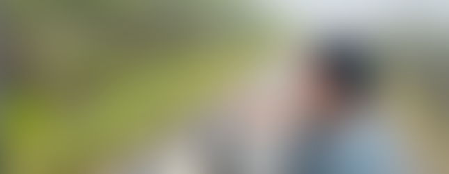 Chrissa on a bicycle looking down at an alligator