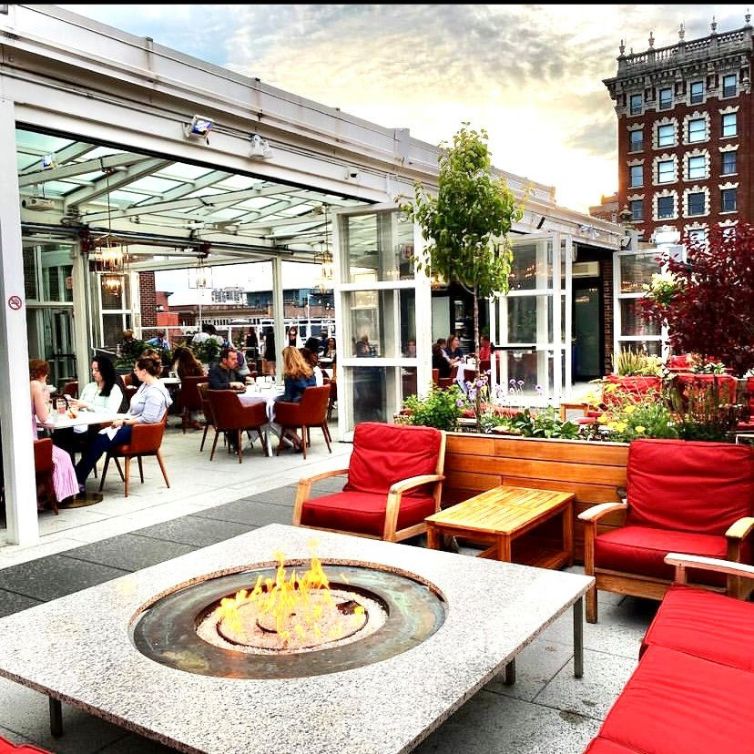 ooftop venue at the Providence G with seating and stunning views of the city skyline.