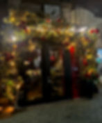 Twinkling lights and garlands decorate the entrance of The Waiting Room in Hoboken during the holiday season.