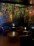 Decorative lounge seating at The Waiting Room, featuring cozy holiday accents, string lights, and festive decor.