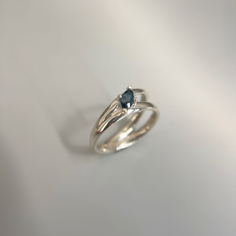 Handcrafted silver ring with London blue topaz — modern open band style.