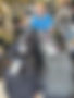 A photo of a volunteer standing behind several school backpacks.