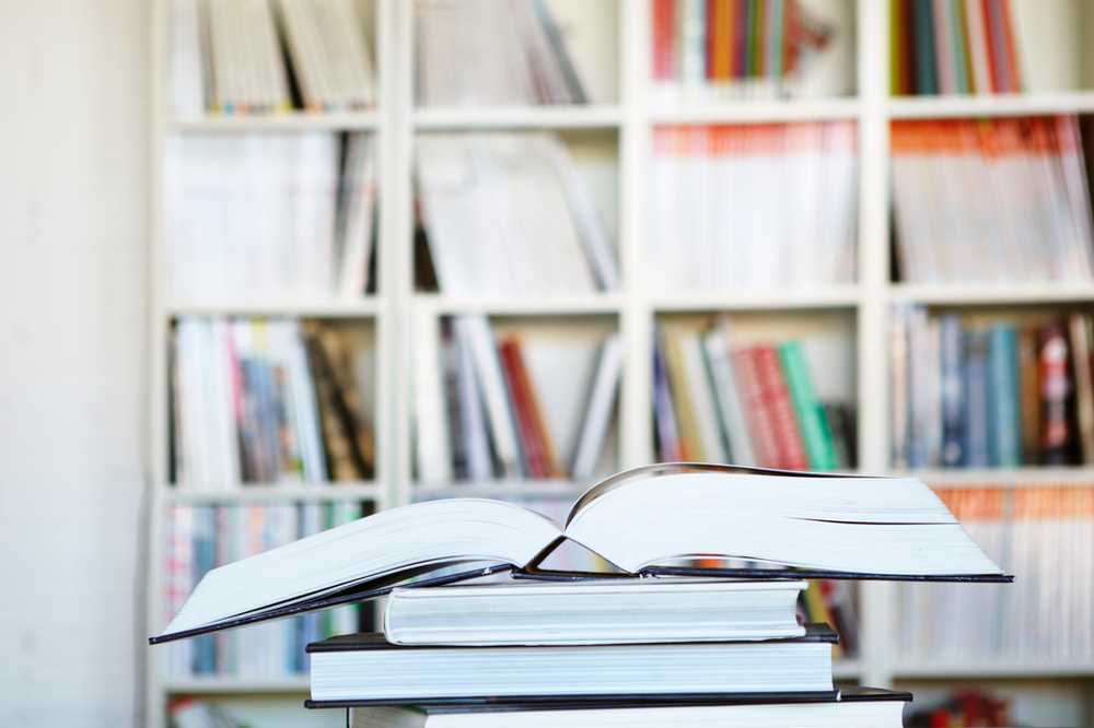 an open book in front of a book shelf