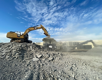 excavator loading heavy equipment with debris
