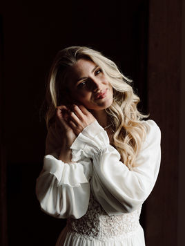 getting ready foto von Braut die sich die Ohrringe anzieht, am Fenster von Villa Mosconi Bertani 