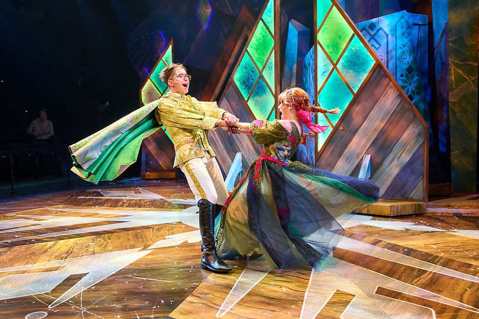 A young man and woman in colorful costumes are holding hands and spinning around in front of stained-glass windows