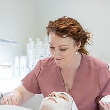Leanne Moss applying a professional facial mask during a skin health treatment in Ipswich clinic.