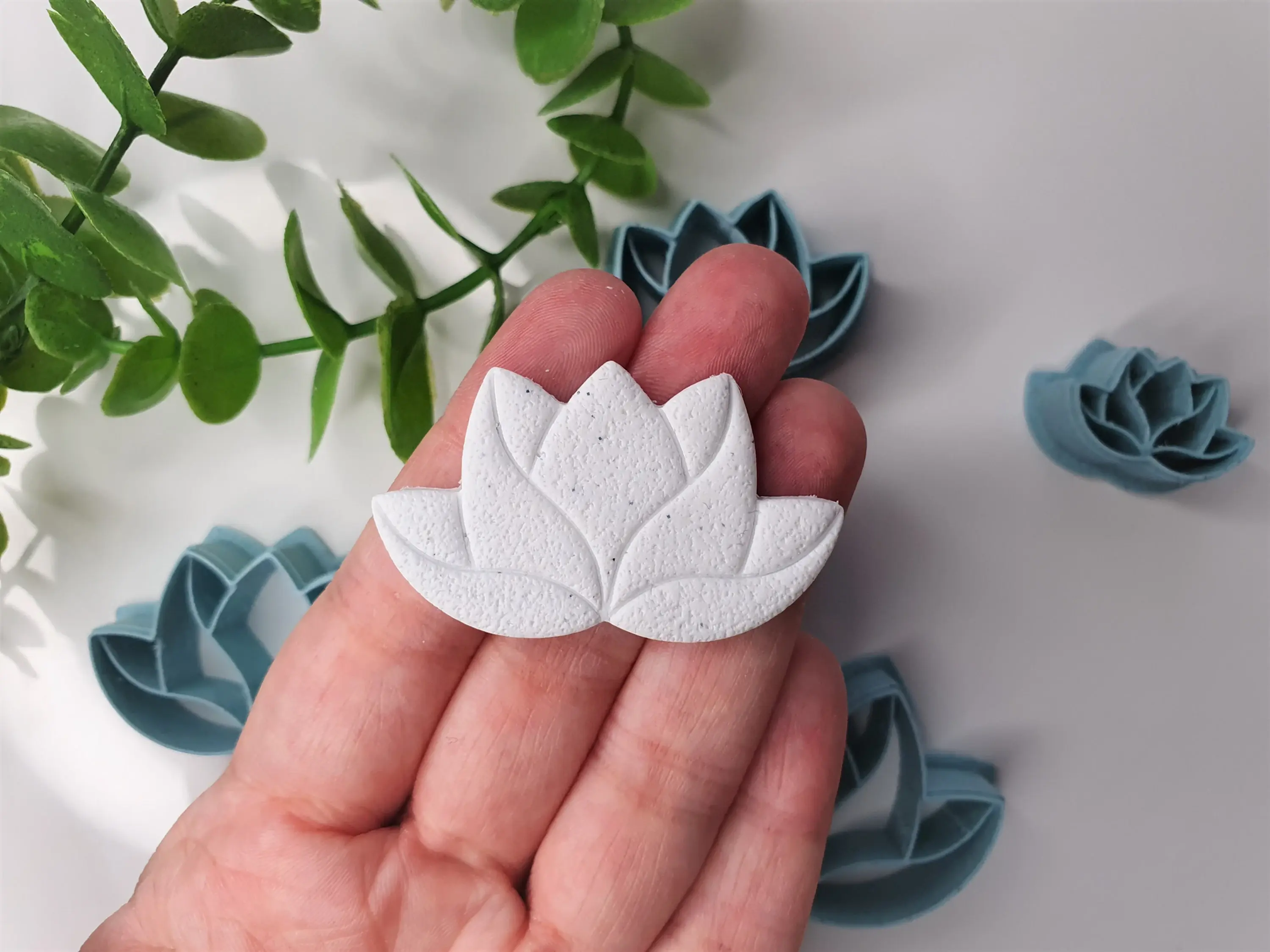 Lotus Flower polymer clay shape shown in hand, shape made by a 3D printed lotus flower cutter