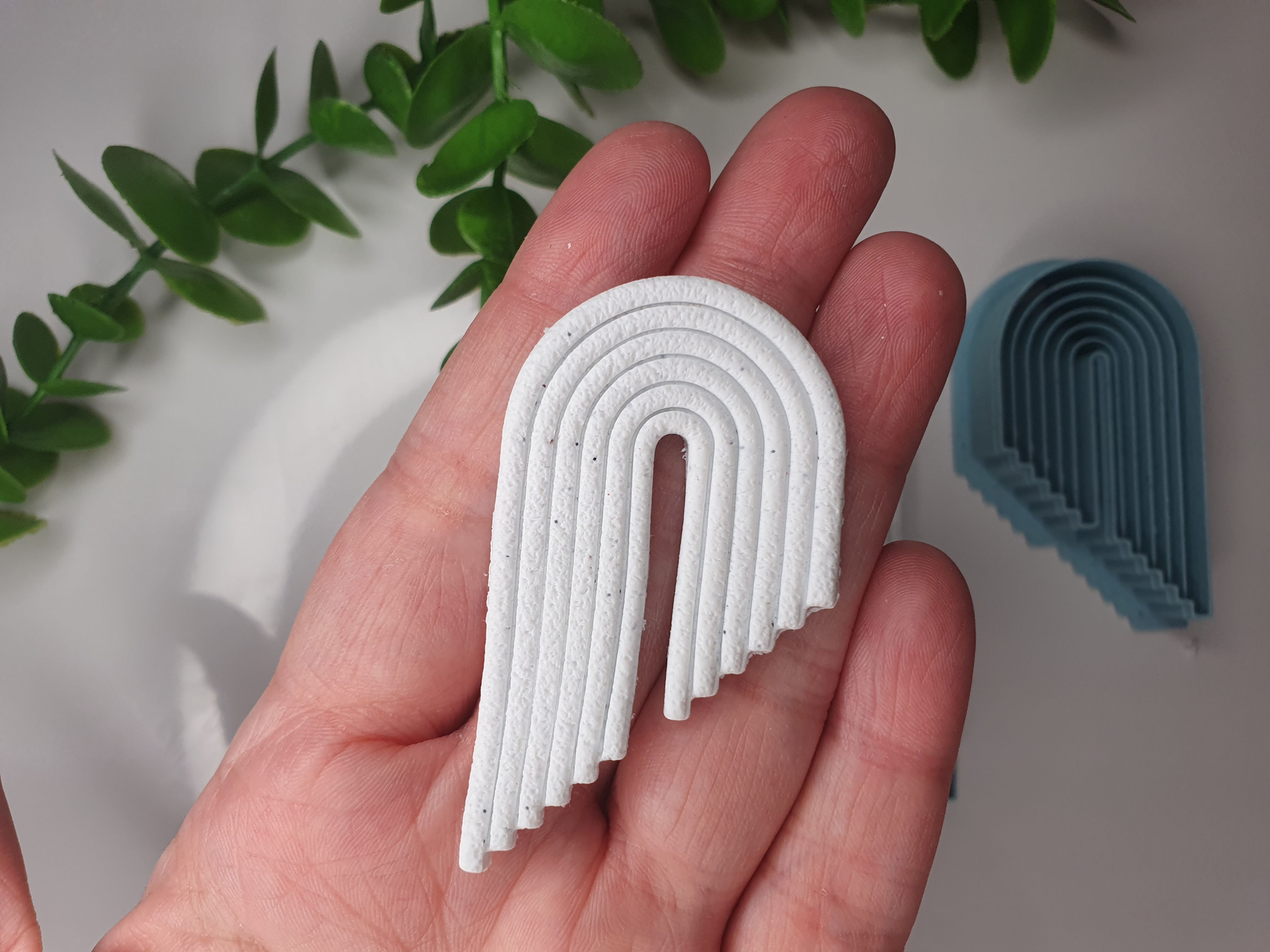 Lined arch polymer clay shape shown in hand, shape made by a 3D printed arch cutter