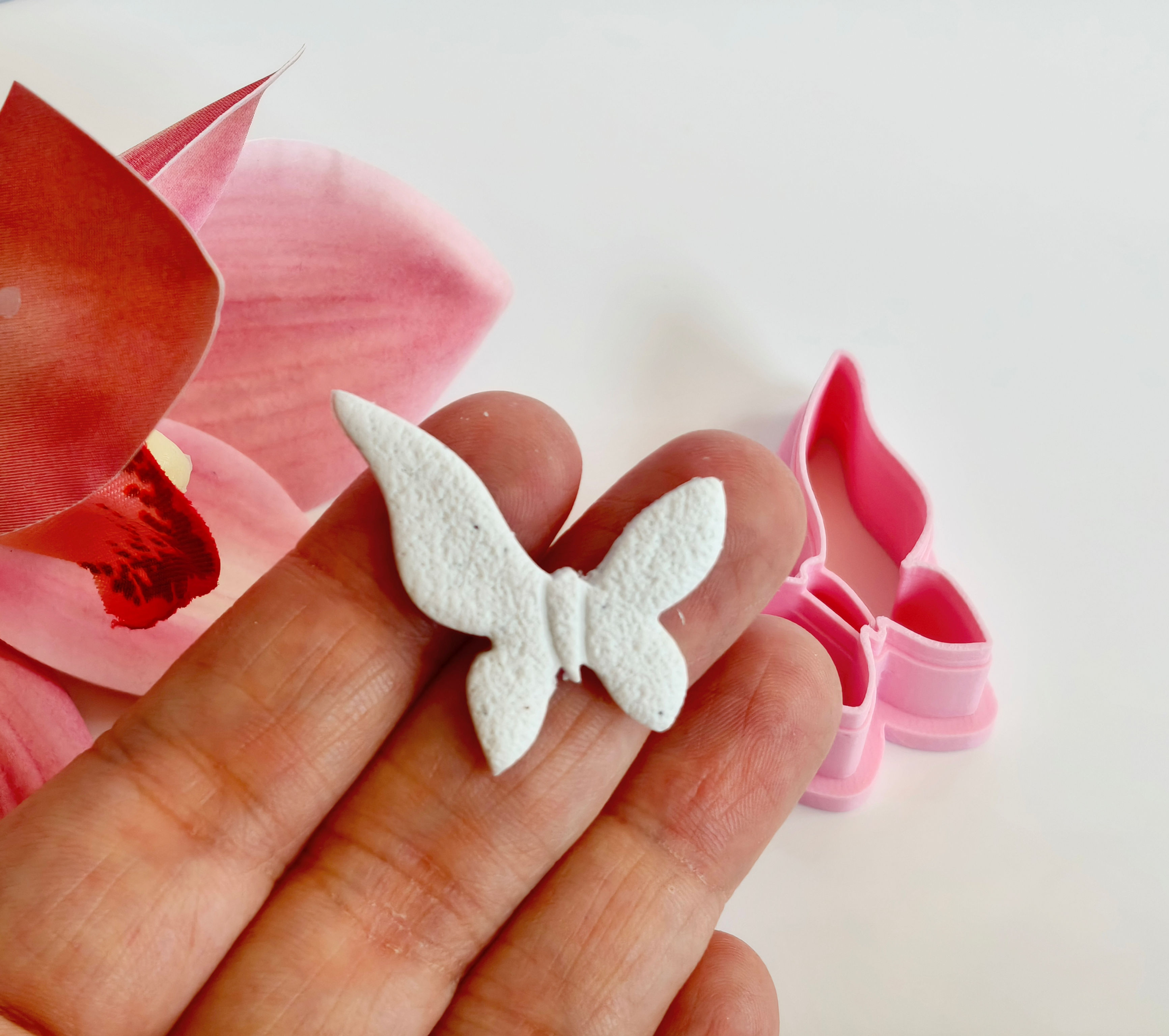 Butterfly polymer clay shape shown in hand, shape made by a 3D printed Butterfly cutter