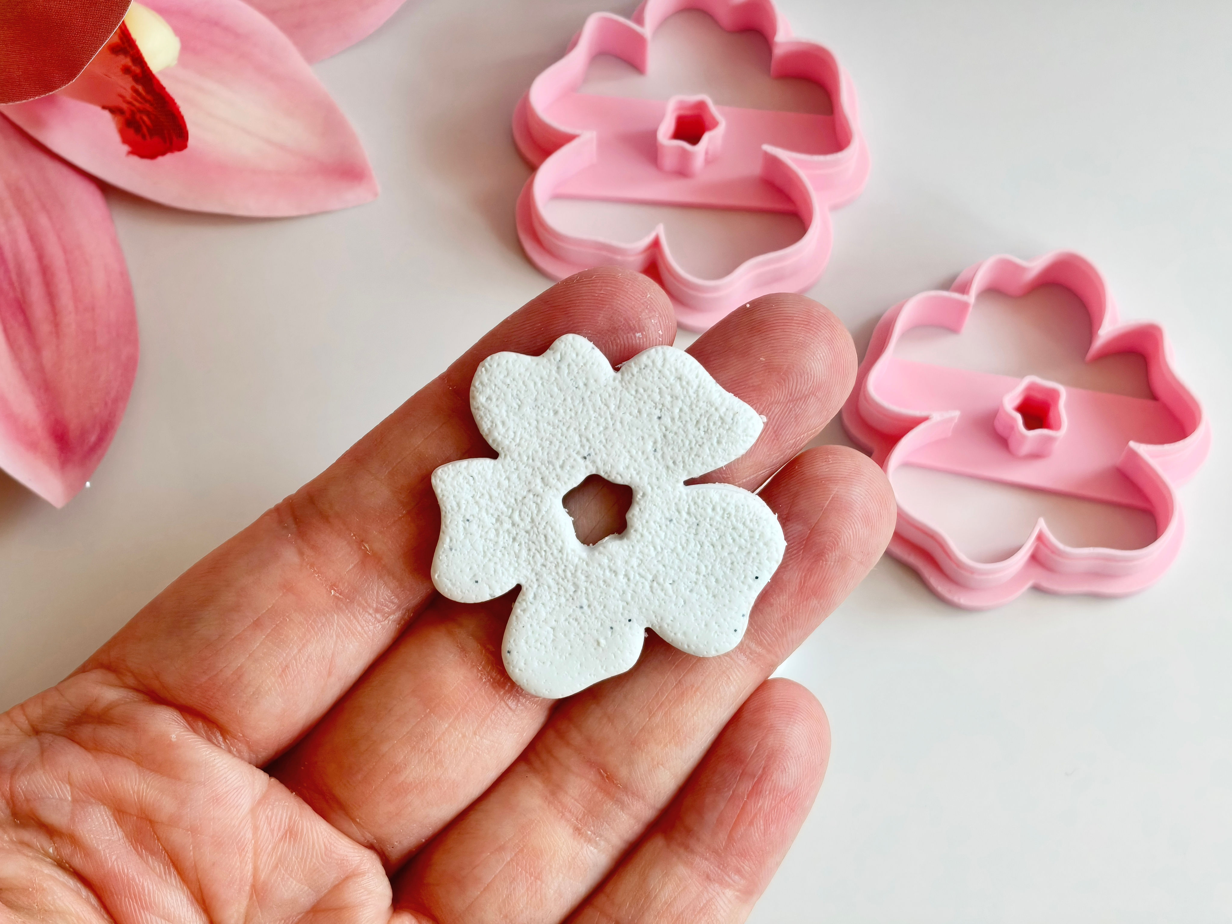 Abstract flower polymer clay shape shown in hand, shape made by a 3D printed floral cutter