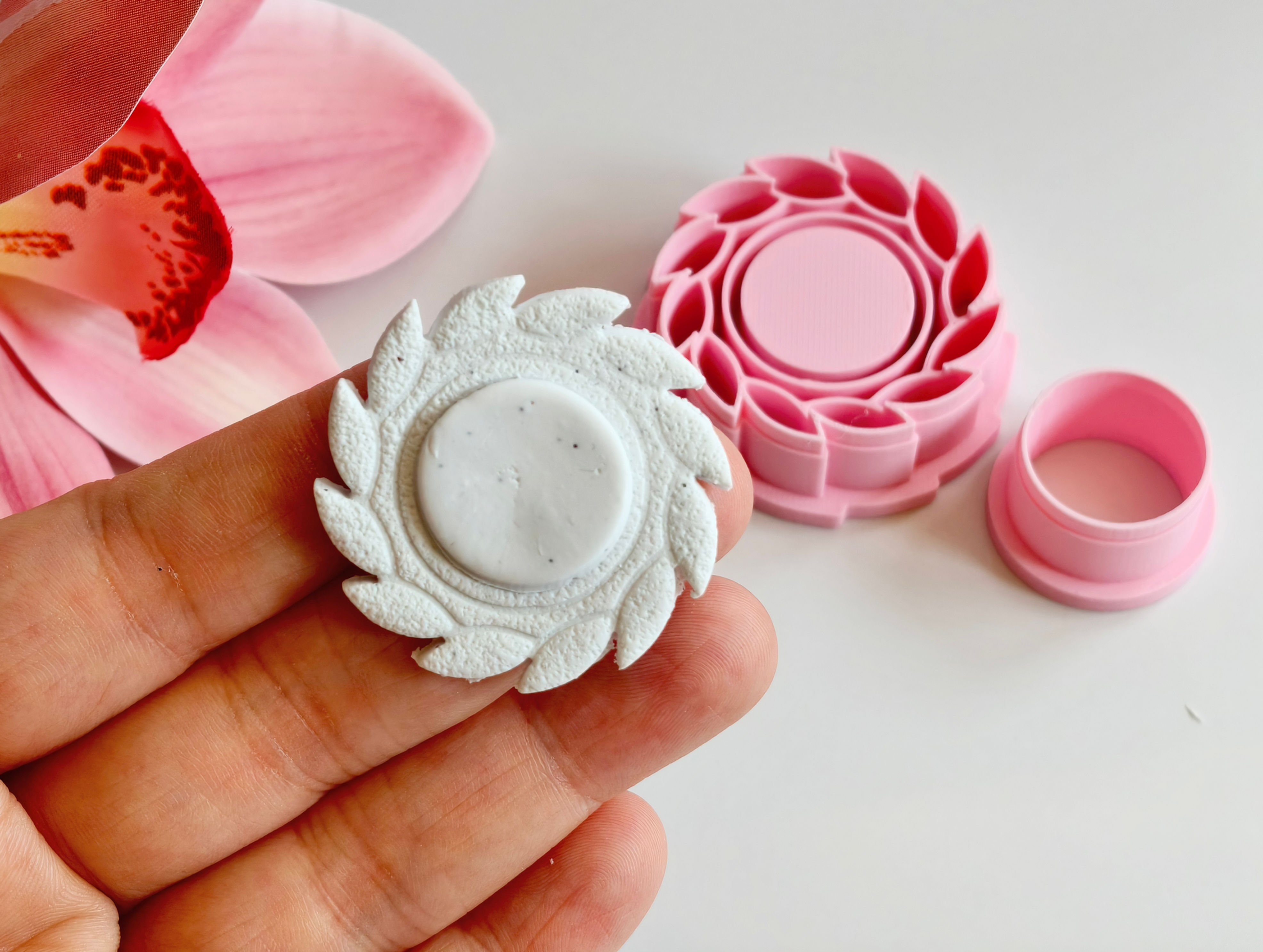 Greek Sun polymer clay shape shown in hand, shape made by a 3D printed greek sun cutter