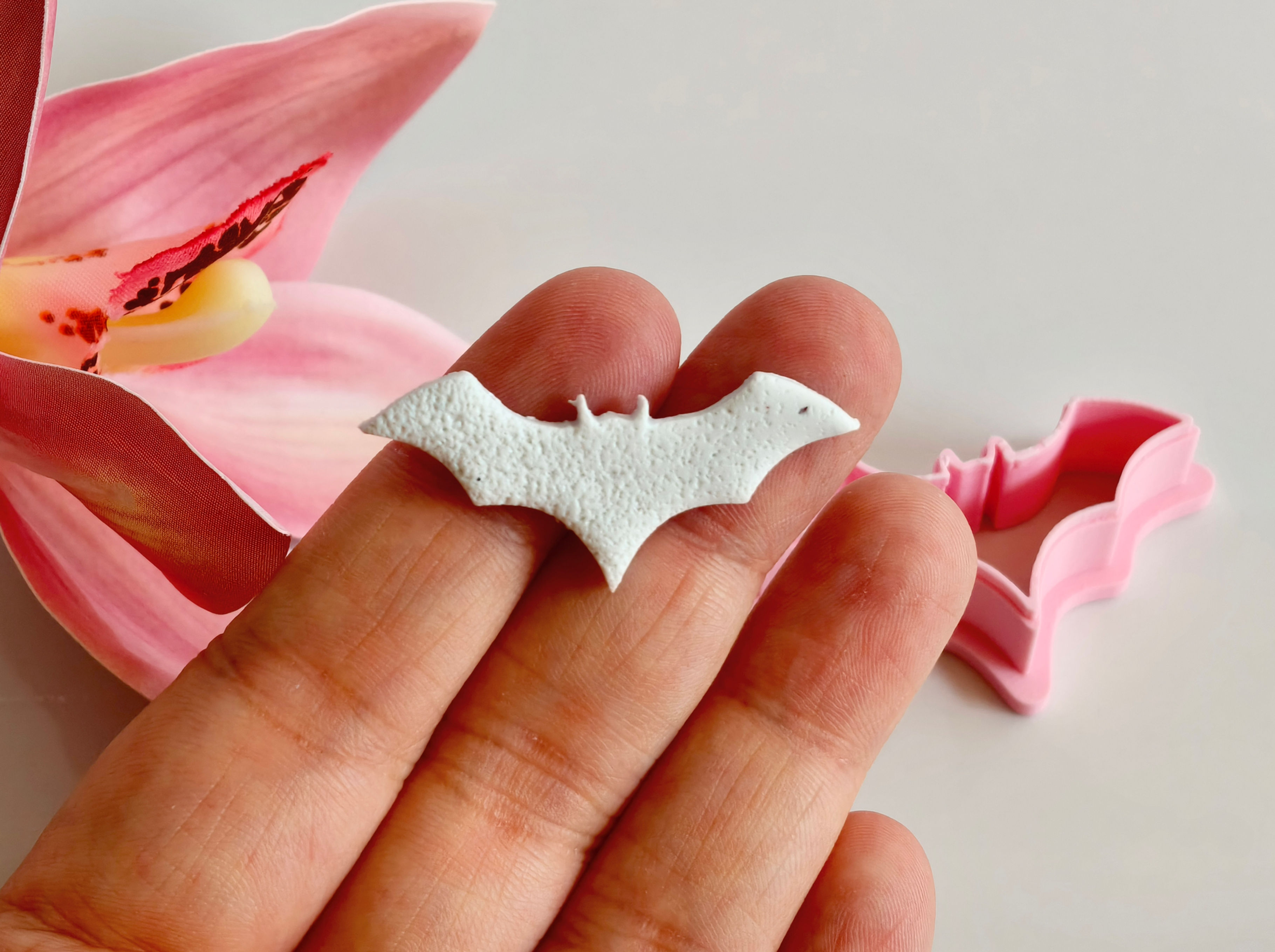 Halloween Bat polymer clay shape shown in hand, shape made by a 3D printed Halloween Bat cutter