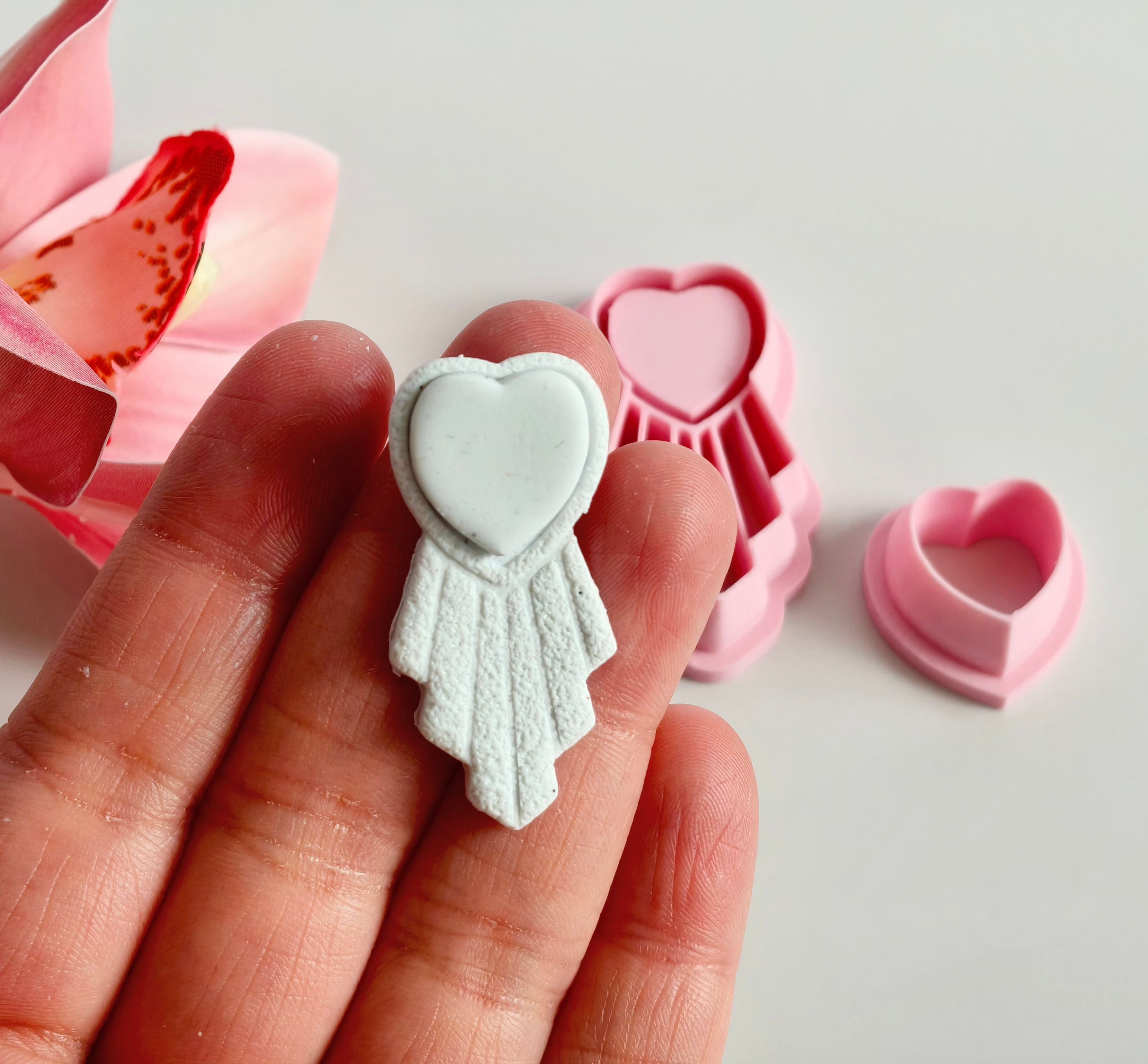 Art Deco Heart polymer clay shape shown in hand, shape made by a 3D printed art deco heart cutter