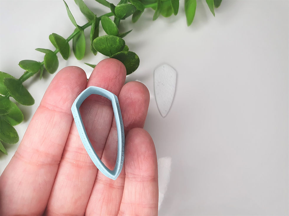Thumbnail: Sharp Shield polymer clay cutter shown in hand, front view, 3D printed cutting tool for jewelry and craft projects
