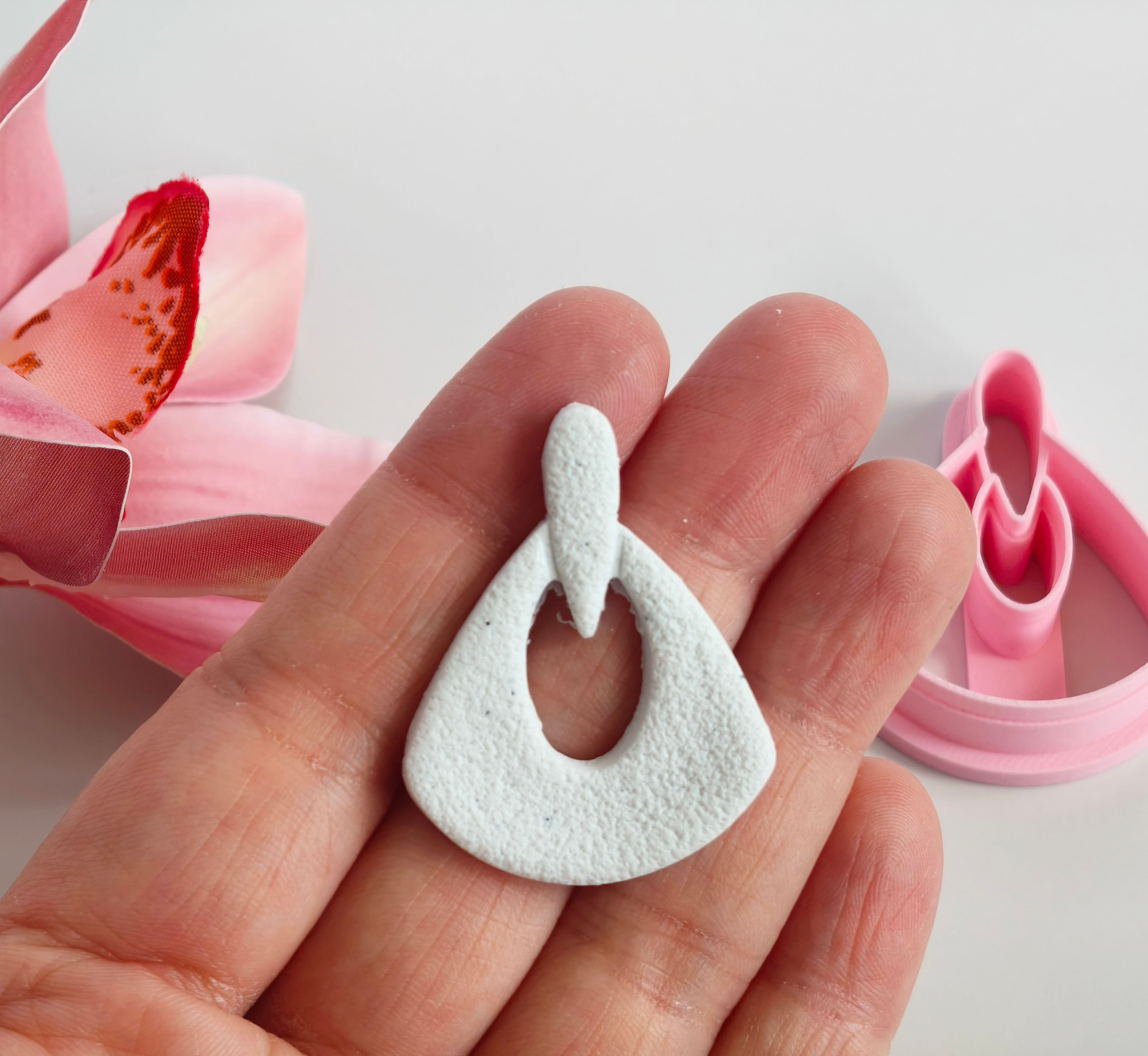 Triangle Dangle polymer clay shape shown in hand, shape made by a 3D printed cutter