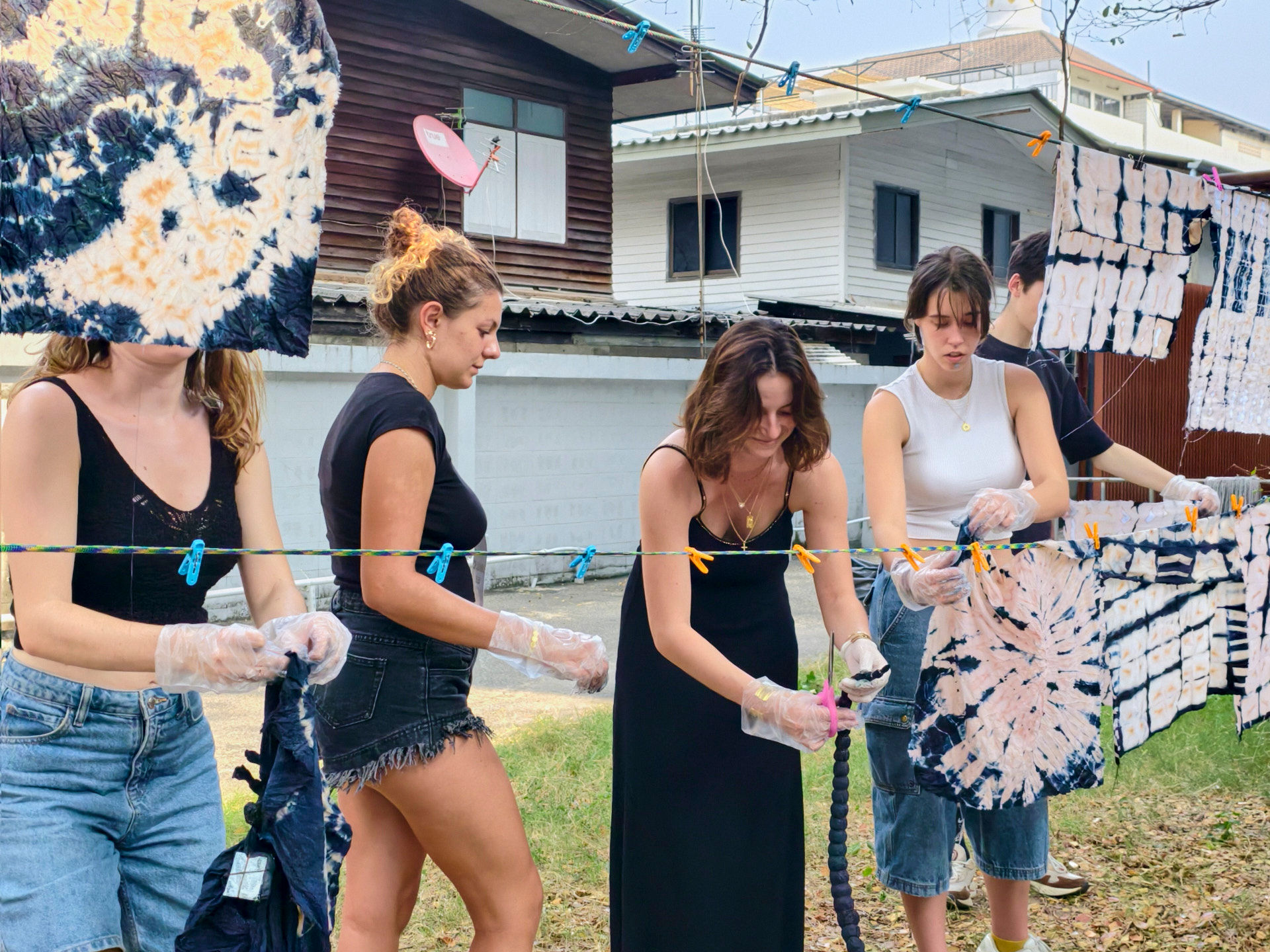 French students participating in a hands-on textile workshop at GIGIPAYNE Studio, working with colorful fabrics around a large table.