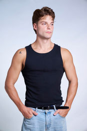 Male professional model in black tank top and blue jeans on blue backdrop at LPS Headshot Studio