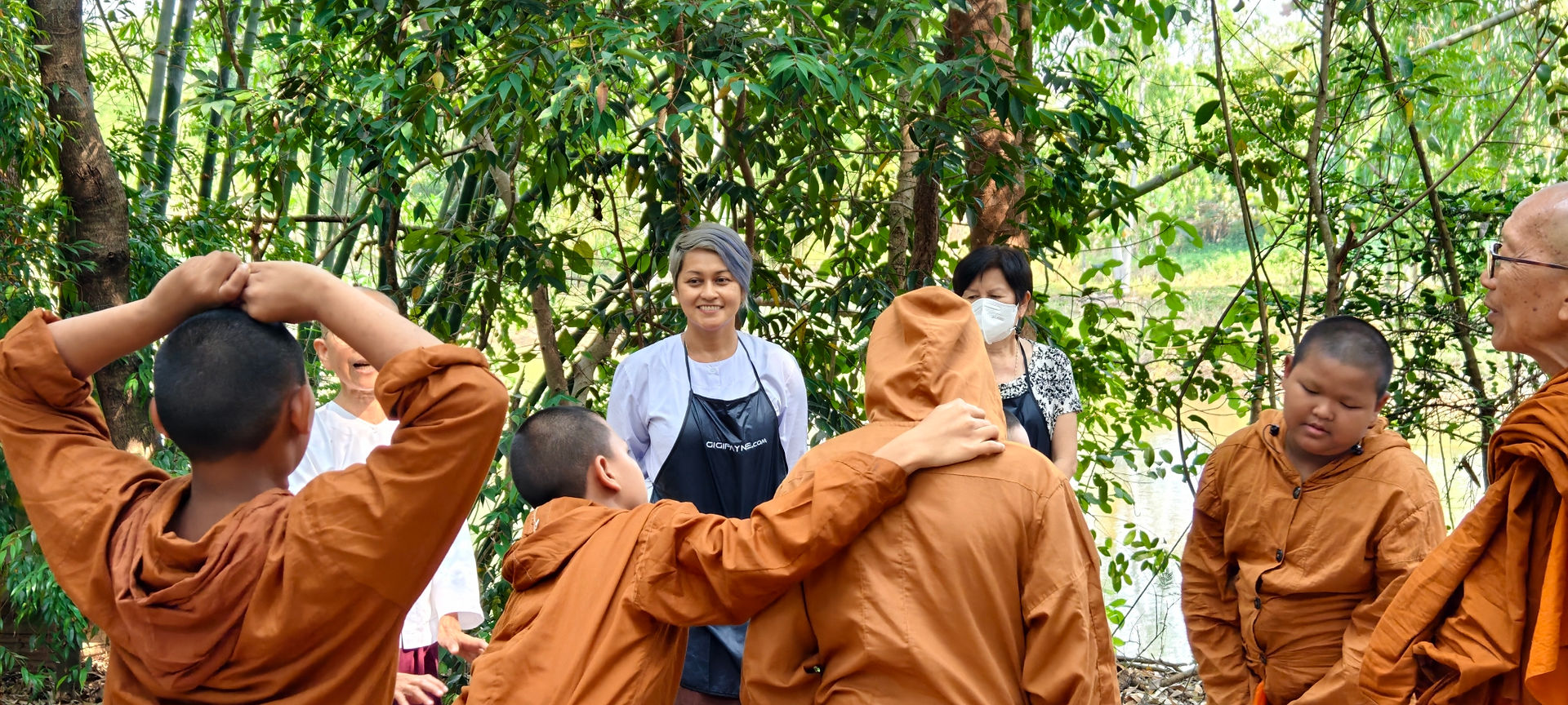 Gigi Payne guiding young student through leaf selection during eco-print craft session at Wat Sukato monastery Thailand